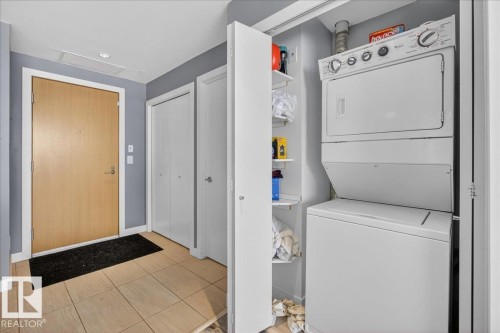 Laundry area with stacked washer and clothes dryer and attic access - 301 2504 109 Street, Edmonton, AB - Indoor Photo Showing Laundry Room