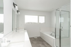 Bathroom featuring double vanity, a garden tub, and a shower stall - 