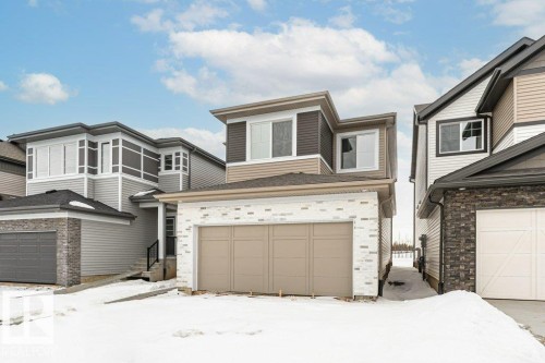 View of front facade featuring a garage and brick siding - 3790 Wren Loop, Edmonton, AB - Outdoor With Facade