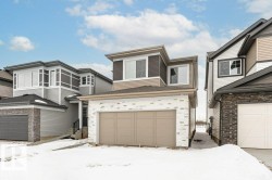 View of front facade featuring a garage and brick siding - 