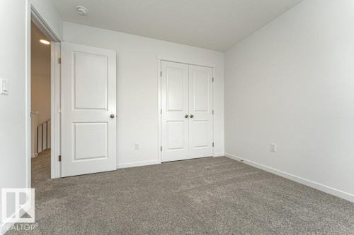 Unfurnished bedroom with dark colored carpet and a closet - 3790 Wren Loop, Edmonton, AB - Indoor Photo Showing Other Room
