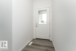 Doorway to outside featuring baseboards and wood finished floors - 