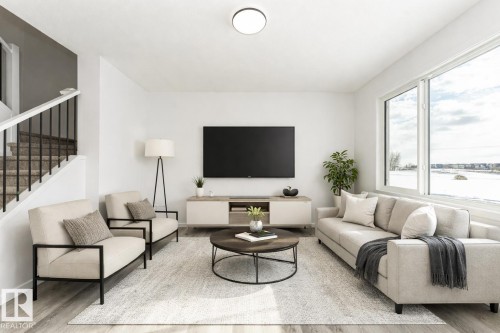 Living area featuring light wood-type flooring and stairs - 3790 Wren Loop, Edmonton, AB - Indoor Photo Showing Living Room