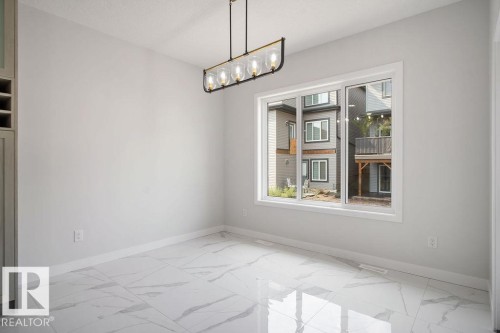 Unfurnished dining area featuring light marble finish floors and suspended lighting - 3912 41 Avenue, Beaumont, AB - Indoor Photo Showing Other Room