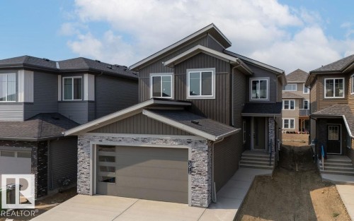 View of front of home featuring board and batten siding, stone siding, an attached garage, and concrete driveway - 3912 41 Avenue, Beaumont, AB - Outdoor With Facade
