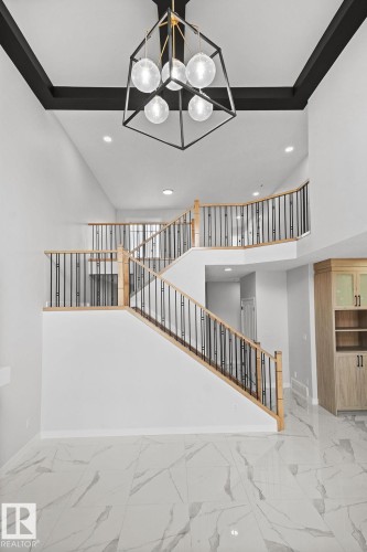 Staircase with a high ceiling, marble finish flooring, and hanging lights - 3912 41 Avenue, Beaumont, AB - Indoor Photo Showing Other Room