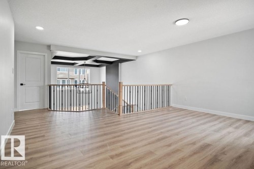 Unfurnished room featuring light wood-style flooring, coffered ceiling, and recessed lighting - 3912 41 Avenue, Beaumont, AB - Indoor Photo Showing Other Room
