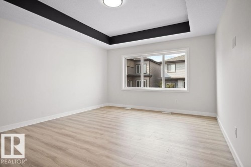 Spare room featuring a raised ceiling and light wood finished floors - 3912 41 Avenue, Beaumont, AB - Indoor Photo Showing Other Room