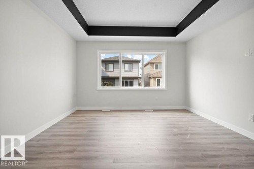 Unfurnished room featuring a raised ceiling and light wood-style floors - 3912 41 Avenue, Beaumont, AB - Indoor Photo Showing Other Room