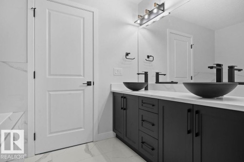 Full bath with double vanity and light marble finish flooring - 3912 41 Avenue, Beaumont, AB - Indoor