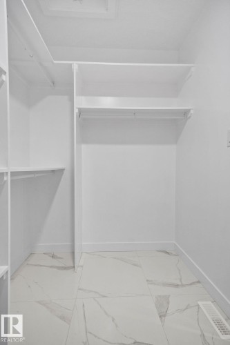 Walk in closet with light marble finish flooring - 3912 41 Avenue, Beaumont, AB - Indoor With Storage