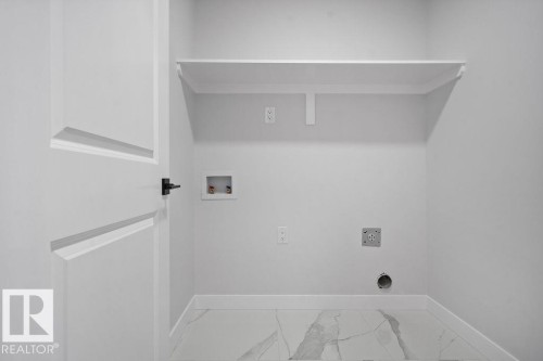 Laundry room with washer hookup and light marble finish flooring - 3912 41 Avenue, Beaumont, AB - Indoor With Storage