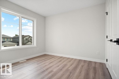 Empty room with light wood-style flooring and baseboards - 3912 41 Avenue, Beaumont, AB - Indoor Photo Showing Other Room