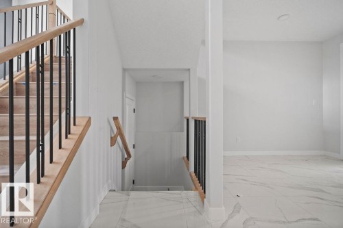 Staircase featuring baseboards and marble look tiles - 3912 41 Avenue, Beaumont, AB - Indoor Photo Showing Other Room