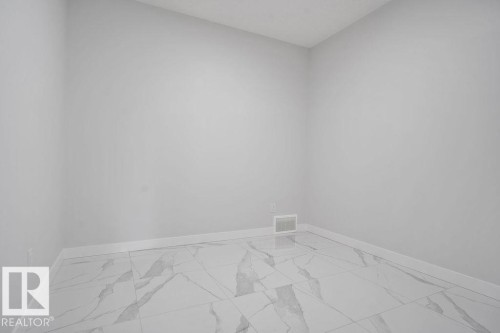 Spare room featuring baseboards and light marble finish flooring - 3912 41 Avenue, Beaumont, AB - Indoor Photo Showing Other Room
