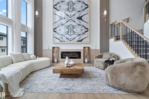 Living room featuring a high ceiling, a glass covered fireplace, and wood finished floors - 13152 187 Avenue, Edmonton, AB - Indoor Photo Showing Living Room With Fireplace