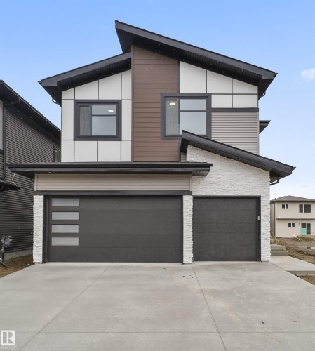 Contemporary house with concrete driveway, an attached garage, and stone siding - 13152 187 Avenue, Edmonton, AB - Outdoor