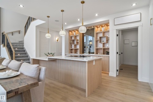 Kitchen featuring light wood finish cabinetry, light wood-type flooring, decorative light fixtures, open shelves, and a kitchen island - 13152 187 Avenue, Edmonton, AB - Indoor Photo Showing Other Room