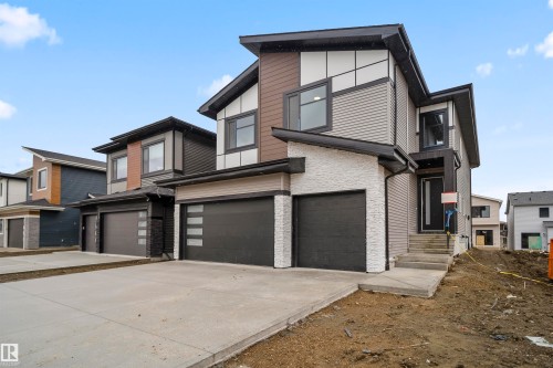Contemporary home with stone siding, concrete driveway, and a garage - 13152 187 Avenue, Edmonton, AB - Outdoor With Facade
