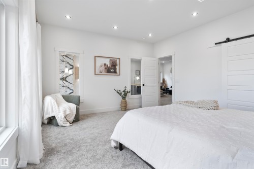 Bedroom with a barn door, carpet flooring, and recessed lighting - 13152 187 Avenue, Edmonton, AB - Indoor Photo Showing Bedroom
