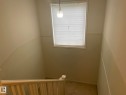 The property features a staircase with a wooden railing and light-colored walls - 2 1295 Carter Crest Road, Edmonton, AB  - Indoor Photo Showing Other Room 