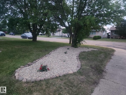View of green lawn featuring a residential view - 4505 57 Avenue, Barrhead, AB - Outdoor
