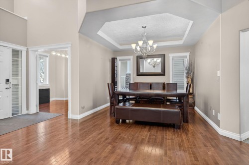 Dining space featuring suspended lighting, a tray ceiling, and dark wood-style flooring - 613 Stewart Crescent, Edmonton, AB - Indoor