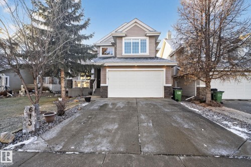 View of front facade with stone siding, driveway, and an attached garage - 613 Stewart Crescent, Edmonton, AB - Outdoor With Facade