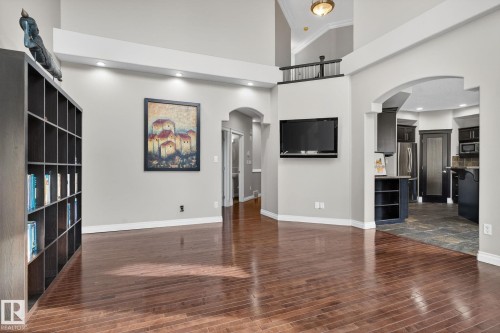 Unfurnished living room with arched walkways, a high ceiling, dark wood-style floors, and recessed lighting - 613 Stewart Crescent, Edmonton, AB - Indoor Photo Showing Other Room