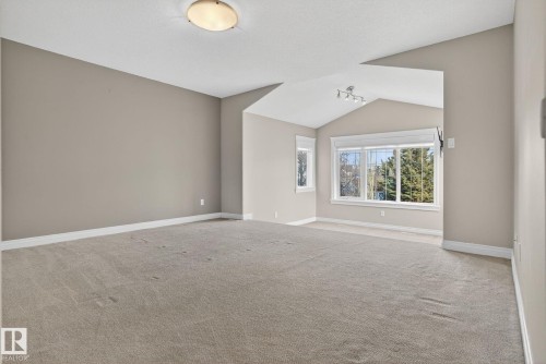 Carpeted spare room featuring baseboards and lofted ceiling - 613 Stewart Crescent, Edmonton, AB - Indoor Photo Showing Other Room