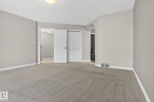 Unfurnished bedroom with arched walkways, light colored carpet, and a closet - 613 Stewart Crescent, Edmonton, AB - Indoor Photo Showing Other Room