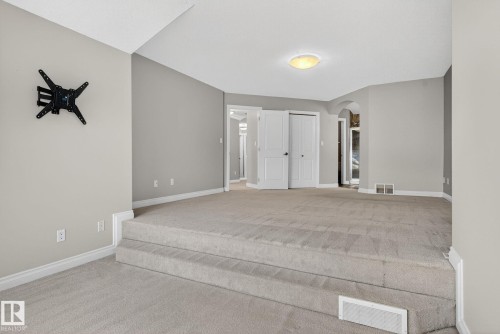 Unfurnished bedroom with arched walkways, light colored carpet, and a closet - 613 Stewart Crescent, Edmonton, AB - Indoor Photo Showing Other Room