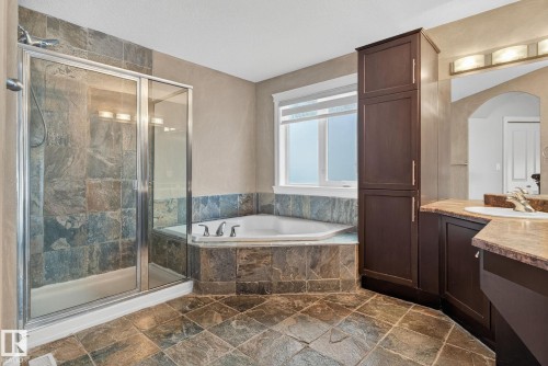 Full bathroom featuring stone tile flooring, vanity, a shower stall, and a garden tub - 613 Stewart Crescent, Edmonton, AB - Indoor Photo Showing Bathroom