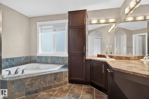 Bathroom with vanity, a bath, and dark stone finish floors - 613 Stewart Crescent, Edmonton, AB - Indoor Photo Showing Bathroom