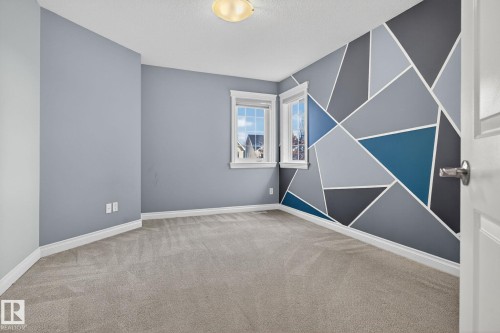 Empty room featuring an accent wall, light colored carpet, and a textured ceiling - 613 Stewart Crescent, Edmonton, AB - Indoor Photo Showing Other Room