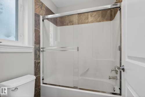 Bathroom featuring toilet and combined bath / shower with glass door - 613 Stewart Crescent, Edmonton, AB - Indoor Photo Showing Bathroom