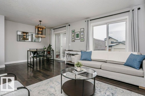 Living room with a textured ceiling, dark wood finished floors, and suspended lighting - 6710 Cardinal Road, Edmonton, AB - Indoor Photo Showing Living Room