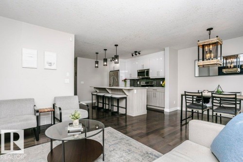 Living room with dark wood-style floors, a textured ceiling, and hanging lights - 6710 Cardinal Road, Edmonton, AB - Indoor