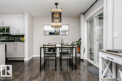 Dining room featuring dark wood-style flooring and a textured ceiling - 6710 Cardinal Road, Edmonton, AB - Indoor