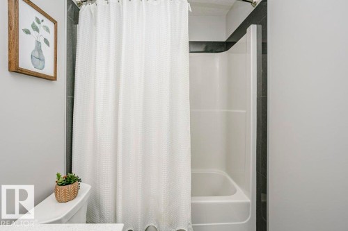 Full bathroom featuring shower / bathtub combination with curtain and toilet - 6710 Cardinal Road, Edmonton, AB - Indoor Photo Showing Bathroom