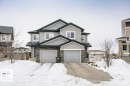 Craftsman-style home featuring stone siding, an attached garage, and driveway - 6710 Cardinal Road, Edmonton, AB  - Outdoor With Facade 