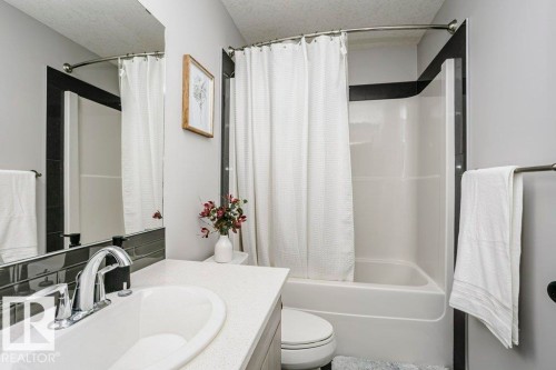 Full bath featuring a textured ceiling, vanity, and shower / tub combo - 6710 Cardinal Road, Edmonton, AB - Indoor Photo Showing Bathroom
