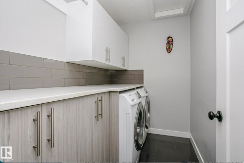 Laundry room with cabinet space and washer and clothes dryer - 6710 Cardinal Road, Edmonton, AB - Indoor Photo Showing Laundry Room