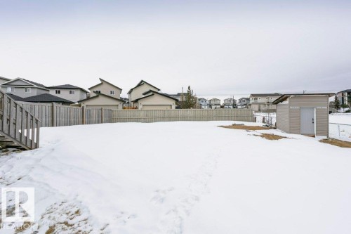 Yard covered in snow with a fenced backyard, a residential view, and a storage shed - 6710 Cardinal Road, Edmonton, AB - Outdoor