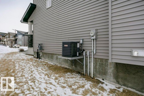 Snow covered property with a cooling unit and a residential view - 6710 Cardinal Road, Edmonton, AB - Outdoor With Exterior