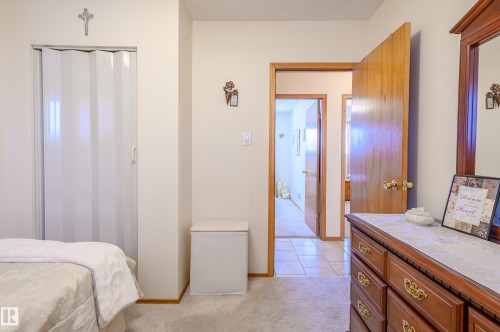 Bedroom with light carpet, a closet, and light tile patterned flooring - 13420 113A St, Edmonton, AB - Indoor Photo Showing Bedroom