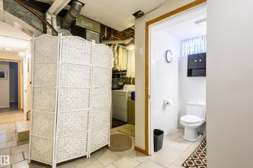 Bathroom featuring washer / dryer and light tile patterned flooring - 13420 113A St, Edmonton, AB - Indoor Photo Showing Bathroom