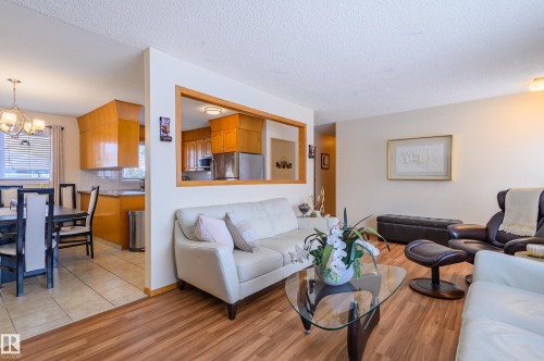 Living room with hanging lights, light wood finished floors, and a textured ceiling - 13420 113A St, Edmonton, AB - Indoor Photo Showing Living Room