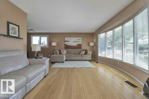 Living area featuring light wood-style floors, a ceiling fan, and a textured ceiling - 4406 39 Ave, Leduc, AB - Indoor Photo Showing Living Room