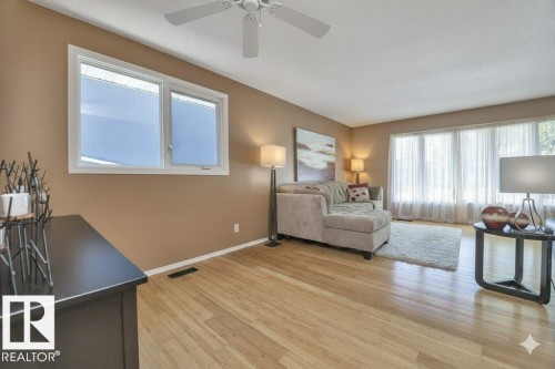 Living area with light wood-style floors, plenty of natural light, and a ceiling fan - 4406 39 Ave, Leduc, AB - Indoor
